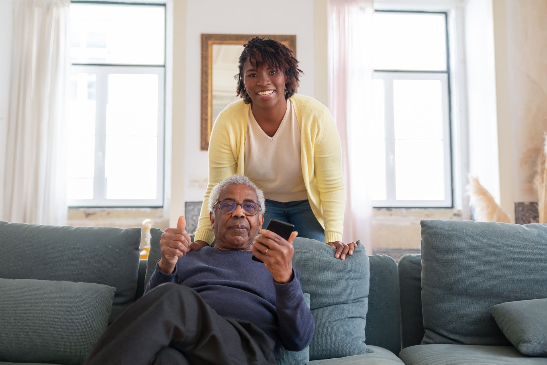 A caregiver and an elderly patient smiling together at home