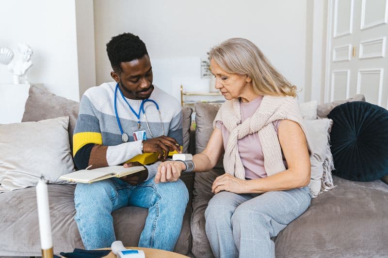 A nurse checking a patient's vital signs at home
